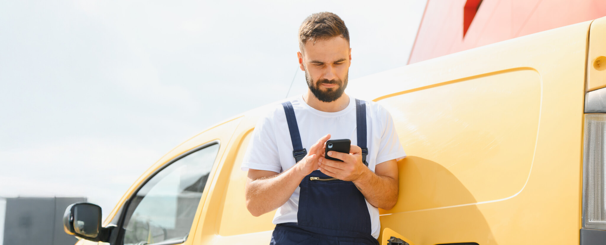 Homem encostado no carro ao telemóvel